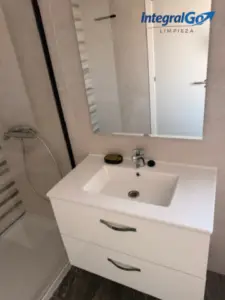 Baño con lavabo y espejo recién limpiados