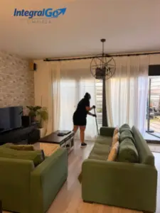 Limpiadora aspirando el salón de una vivienda